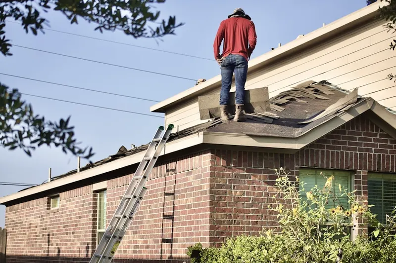 Professional roofer working on a residential roof in Sunset